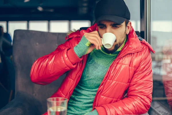 Handsome guy relaxing and drinking coffee on a cold day — Stock Photo, Image
