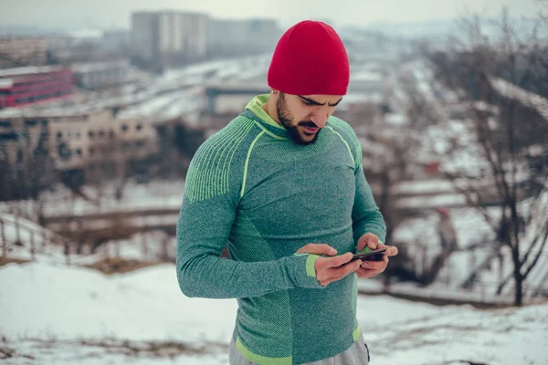 Hombre atlético tomando un descanso del entrenamiento y viendo videos —  Fotos de Stock