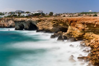 Deniz dalgaları kayalara çarpıyor. Yavaş deklanşör hızı