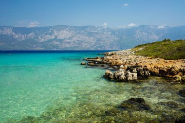 Ege Denizi 'ndeki adanın kıyısında dağların arka planında