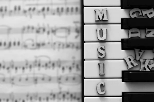 Pianotangenter närbild med bokstäver musik — Stockfoto