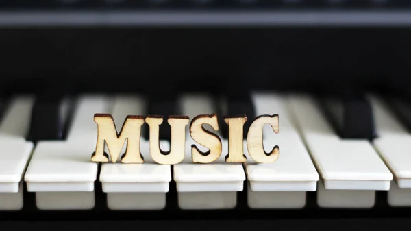 Клавіші піаніно крупним планом з музикою літер — стокове фото