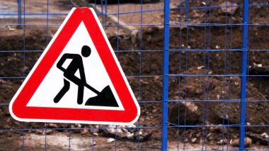 İskoçya'daki işlek bir yolda eski Roadworks işareti