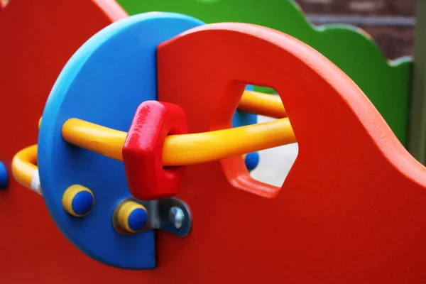 Row of colorful plastic rings on a metal pin at a playground
