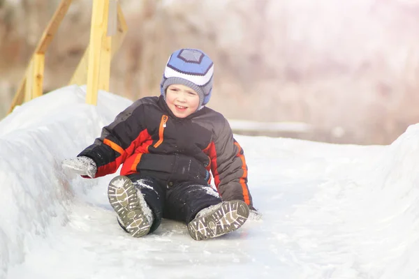 Niño rueda por la colina en la nieve —  Fotos de Stock