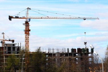 Yapı vinci ve mavi gökyüzüne karşı bina.