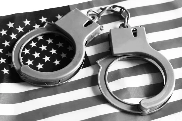 US-Rechtssystemkonzept, Handschellen im Hintergrund und amerikanische Flagge — Stockfoto
