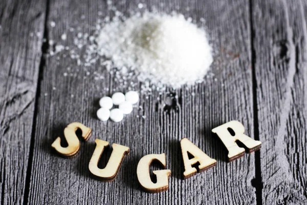 Zoetstof tablet en suiker. Tekst suiker houten letters. — Stockfoto