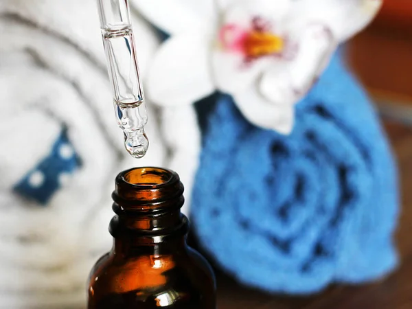 Ácido hialurônico em frasco com pipeta, toalha e orquídea — Fotografia de Stock