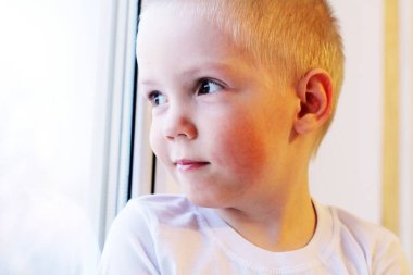 Pencere, çok üzgün oturan sevimli küçük sarışın çocuk çocuk