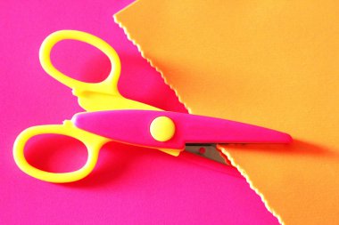 Şekilli makas pembe kağıt üzerinde. Dekorasyon için makas