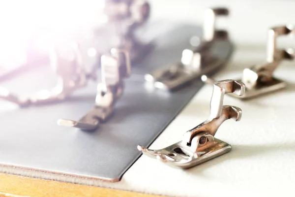 Grupo de acessórios da máquina de costura. Vários pés de prensas são usados para diferentes tarefas e tipos de tronco . — Fotografia de Stock