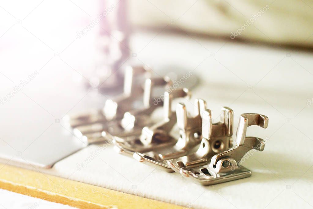 Group of sewing machine accessories. Various presser feet are used for different tasks and stem types.