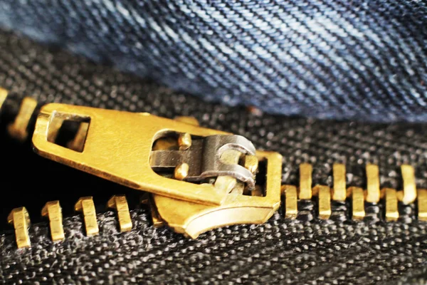 Metall blixtlås och lock på jeans bakgrund, makro — Stockfoto