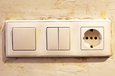 Elektrik düğmesi ve boş duvardaki soket, elektrik prizi ve fişi değiştirilmiş.