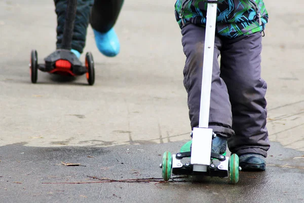 Crianças montando uma scooter, pés — Fotografia de Stock