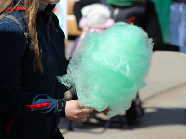 The hands of women holding green cotton candy
