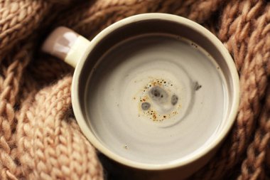 Bir fincan sıcak kahve ve sıcak bej eşarp.