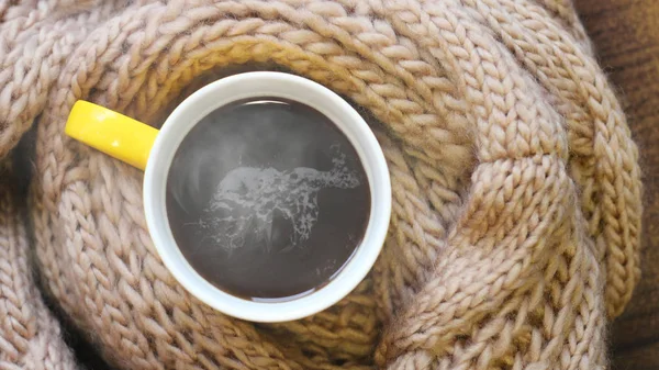 Žlutý šálek horké kávy a béžový teplý šátek — Stock fotografie