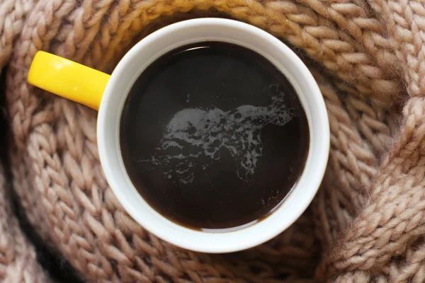 Жовта чашка гарячої кави і бежевий теплий шарф. — стокове фото