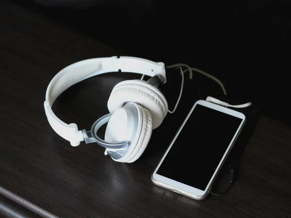 Білі навушники з мобільним смартфоном — стокове фото