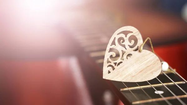 Dřevěné srdce na strunách kytary — Stock fotografie