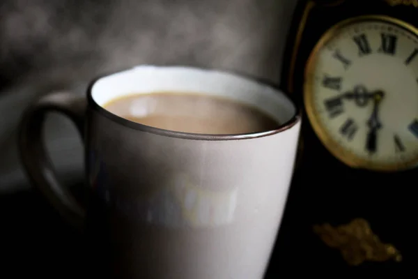 木のテーブルの上の目覚まし時計とコーヒー豆はとても近い — ストック写真