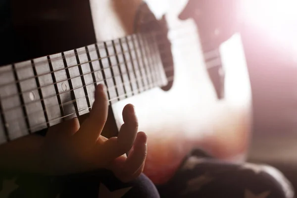 Çocuk eli ve gitarı, çalmayı öğrenmek.