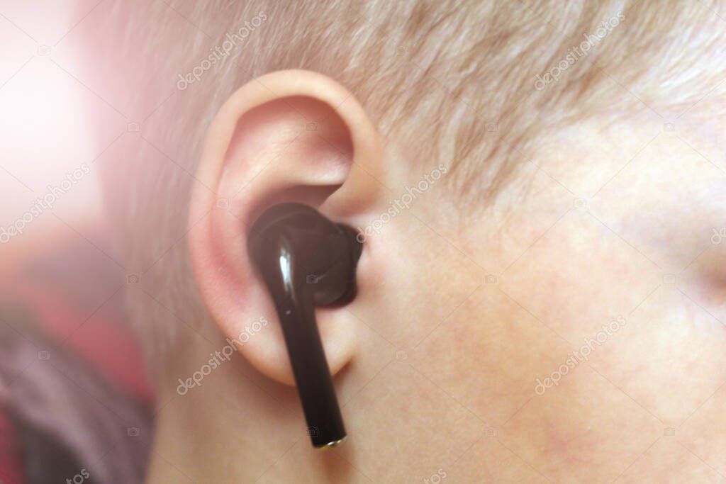 Black wireless earphone with ear so close