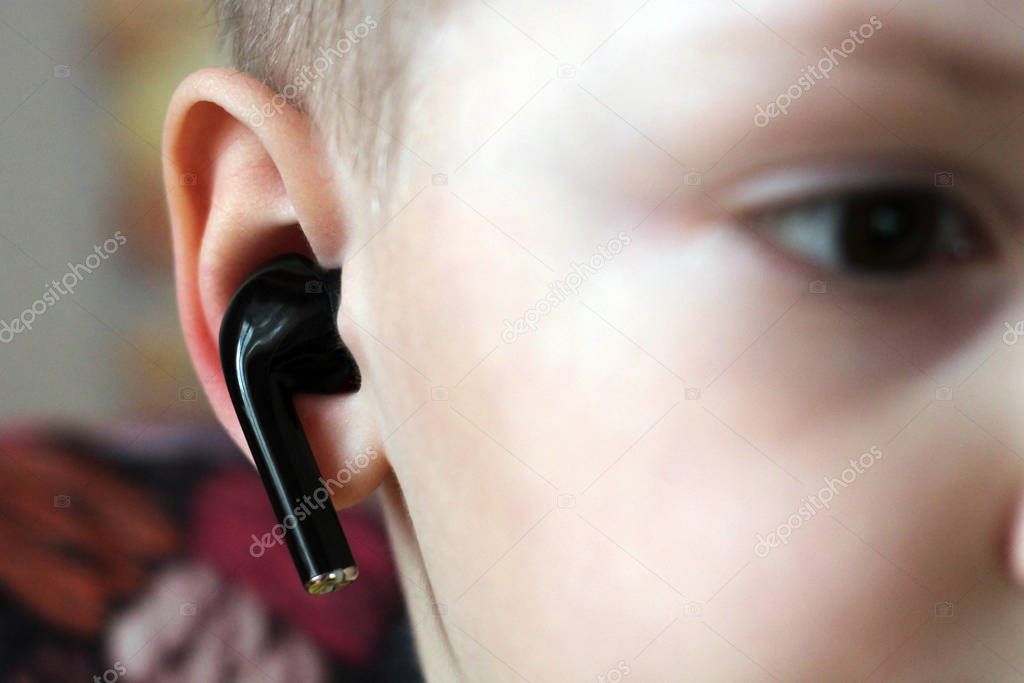 Black wireless earphone with ear so close