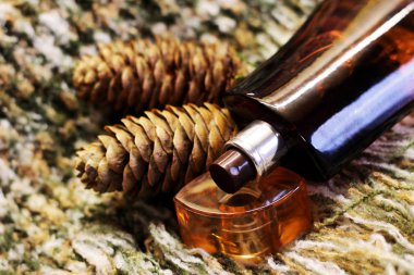 Kahverengi cam ve köknar kozalakları, parfüm kompozisyonu, lüks nesneler.