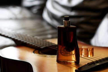 Erkek cam parfümü ve gitar çok yakın, kahverengi