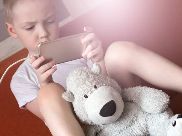 Menino Brincando Com Smartphone Urso Branco Brinquedo — Fotografia de Stock