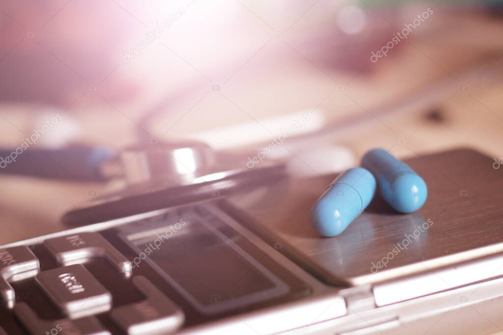 Medical capsules on electronic scales, pharmacist theme so close