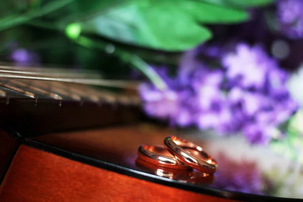 Anneaux Mariage Sur Les Cordes Guitare Des Fleurs Violettes Près — Photo