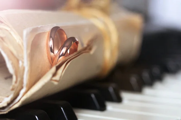 两只金戒指和一些旧的乐谱钢琴钥匙 — 图库照片