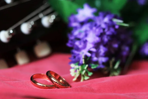 Свадебные Кольца Шнурах Гитары Фиолетовые Цветы Близко — стоковое фото
