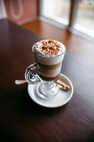 Broodje en kopje koffie op een houten tafel — Stockfoto