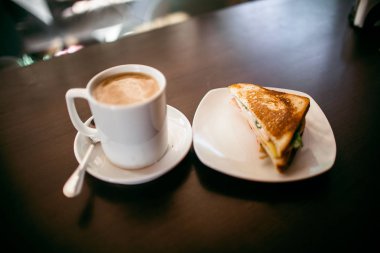 ahşap bir masa üzerinde sandviç ve Kupası kahve