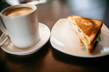 ahşap bir masa üzerinde sandviç ve Kupası kahve