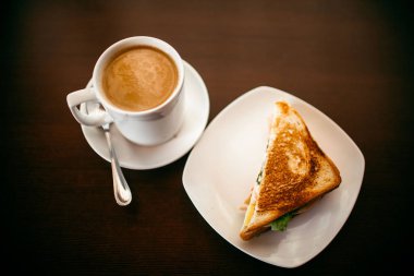 ahşap bir masa üzerinde sandviç ve Kupası kahve