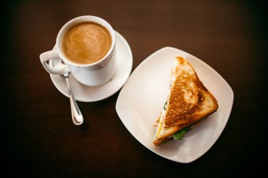 ahşap bir masa üzerinde sandviç ve Kupası kahve