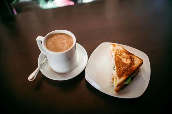 Sandwich și ceașcă de cafea pe o masă de lemn — Fotografie, imagine de stoc