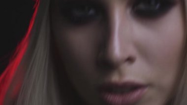 Güzel genç kadın dumanlı gözler makyaj ile yakın çekim görünümünü koyu arka plan üzerinde 