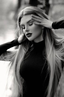 Genç bir kadın köprüsü olan bir nehrin kıyısında suyun üzerinde tek başına duruyor. Sisli hava. Sabahın erken saatlerinde. Karanlık, korkunç bir an ve kasvetli bir atmosfer. Siyah beyaz fotoğraf