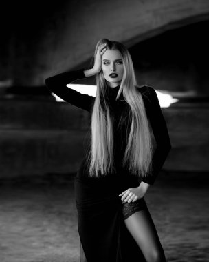 Genç bir kadın köprüsü olan bir nehrin kıyısında suyun üzerinde tek başına duruyor. Sisli hava. Sabahın erken saatlerinde. Karanlık, korkunç bir an ve kasvetli bir atmosfer. Siyah beyaz fotoğraf