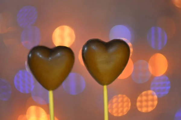 Chocolates em forma de coração em paus — Fotografia de Stock