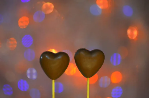 Chocolates em forma de coração em paus — Fotografia de Stock