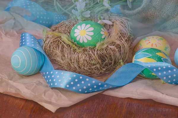 Ostereier im Nest und Schneeglöckchen — Stockfoto