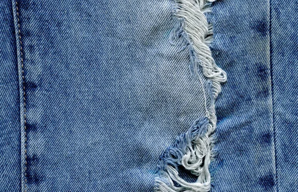 Hole and threads on denim jeans — Stock Photo, Image